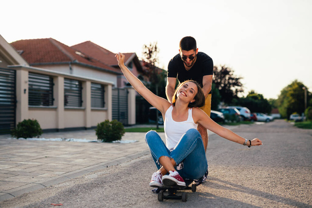friends having fun while driving skateboard outdoor - Фото, изображение