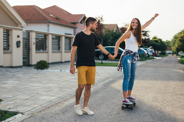 friends having fun while driving skateboard outdoor - Photo, image