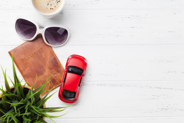 Travel vacation concept with sunglasses, passport, car toy and coffee on wooden backdrop. Top view with copy space. Flat lay - Photo, Image
