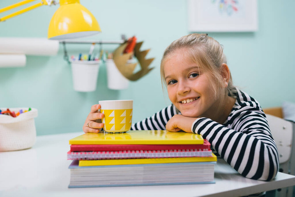 schoolgirl in her room sitting table and posing - Foto, Bild