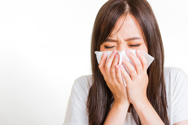 Portrait of Asian beautiful young woman sad she crying wipe the mucus with tissue, Close up of pretty girl sneezing sinus using towel to wipe snot from nose, studio shot isolated on white background - 写真・画像