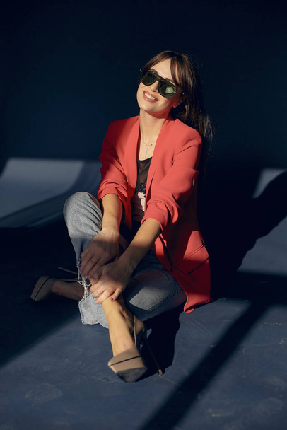 Fashion girl in a sunglasses sitting on the floor - Fotó, kép
