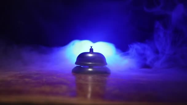 close-up beelden van de dienst bel op tafel op donkere achtergrond met verlichting - Video