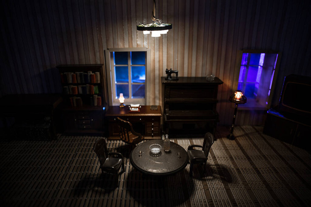 Realistický obývací pokoj pro panenky s nábytkem a oknem v noci. Dekorace uměleckého stolu s ručně vyrobeným realistickým domečkem pro panenky. Selektivní zaměření. - Fotografie, Obrázek