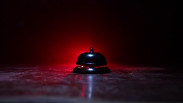 close-up beelden van de dienst bel op tafel op donkere achtergrond met verlichting - Video
