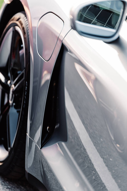 Alesund / Norwegia - 31 maja 2020: Srebrny Porsche Taycan sedan na parkingu, zaparkowany w celach promocyjnych. Szczegóły zewnętrzne strzał z bliska.  - Zdjęcie, obraz