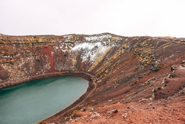 A Kerid-tó egy krátertó vagy vulkáni tó, egy izlandi vulkán kráterében. Szokatlan vörös talaj, hasonló a marsi tájak. - Fotó, kép
