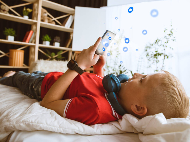 Boy connecting and sharing social media. Modern UI icons, communication, devices - 写真・画像