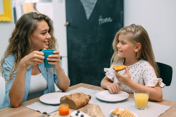 mother and daughter having breakfast at home - Photo, Image