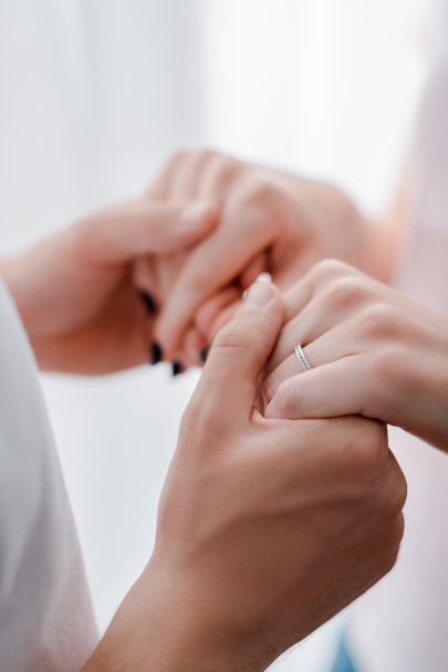 cropped view of woman with engagement ring on finger holding hands with man  - Photo, Image