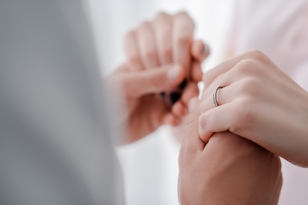 selective focus of woman with engagement ring on finger holding hands with man  - Fotó, kép