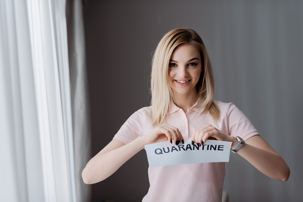 glückliche Frau reißt Papier mit Quarantäne-Schriftzug  - Foto, Bild