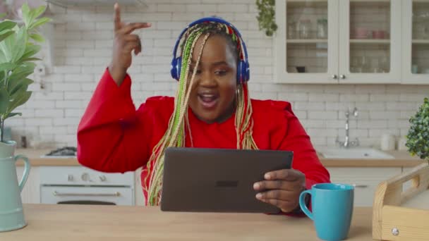 Joyful black female browsing content on tablet pc - Video, Çekim
