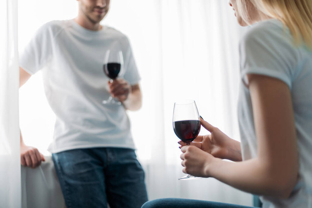 vue recadrée de l'homme et de la femme tenant des verres avec du vin rouge à la maison
 - Photo, image