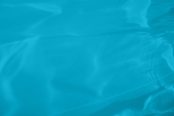 Trendy mintblau gefärbt kontrastarmen abstrakten Hintergrund mit Licht und Schatten ätzende Wirkung. Durch ein Glas fällt Licht. Wasserhintergrund. Farbtrend des Jahres 2021 - Foto, Bild
