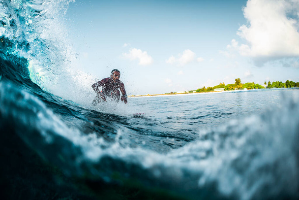 Mladý muž jezdí na vlně oceánu. Extrémní sport a aktivní životní styl koncept - Fotografie, Obrázek