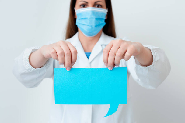 Osoba nosząca suknię medyczną Rękawice chirurgiczne Maska chirurgiczna Różny kąt ujęcia wykonane z pustą naklejką Akcesoria papierowe Nowoczesny smartfon - Zdjęcie, obraz