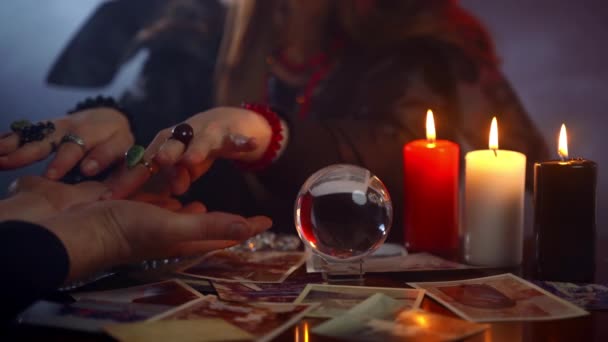 Paranormal phenomena and chiromancy in dark magic room, young fortune teller reading fate lines on mans hand and predicting happy future life or bad news. Witchcraft and esoteric concept - Footage, Video