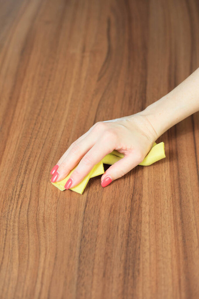 Joven mujer limpieza a mano mesa de madera moderna por paño de polvo, concepto de limpieza
 - Foto, Imagen