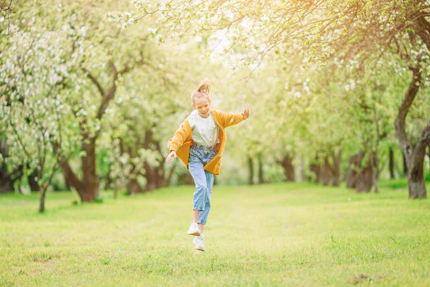 Ένα χαμογελαστό κορίτσι που παίζει στο πάρκο. - Φωτογραφία, εικόνα
