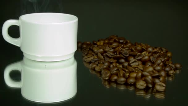 Humo de una taza blanca, granos de café, sobre un fondo verde grisáceo. Macro
 - Metraje, vídeo