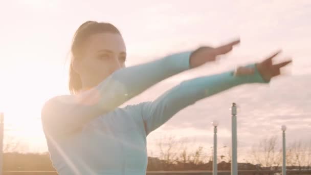 Young, beautiful and sporty woman having evening training outdoor. Urban sunset background. Fitness and sport concept. - Filmati, video