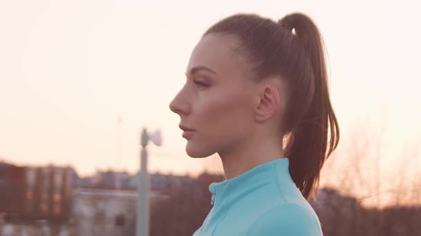 Young, beautiful and sporty woman having evening training outdoor. Urban sunset background. Fitness and sport concept. - Filmmaterial, Video