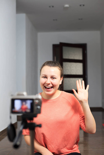 Young female blogger recording a video for her subscribers by a professional camera, vlog - Foto, imagen