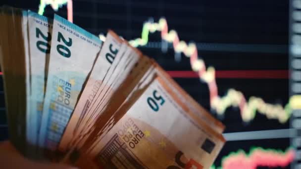 Euro banknotes on charts background, trader holding 20 and 50 euro currency. Analysis and data statistics, stock market crash. Loss of assets and shares, concept of inflation and financial crisis in - Footage, Video
