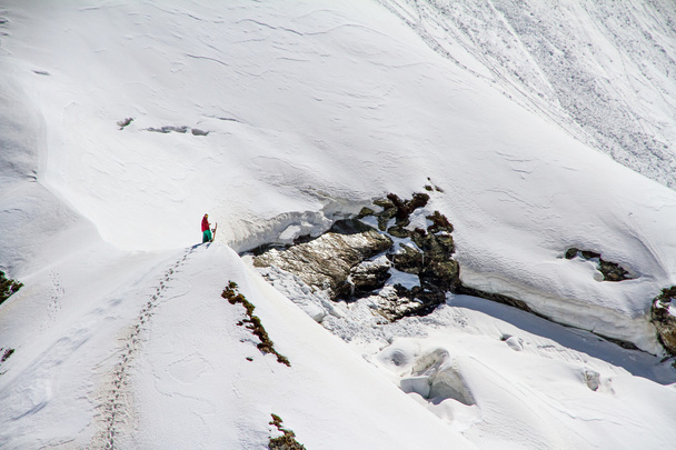Skier climbing a snowy mountain - Fotó, kép