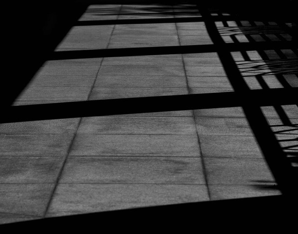 σκιά από γυάλινο παράθυρο σε μαρμάρινο τοίχο στο δωμάτιο - μονόχρωμη - Φωτογραφία, εικόνα