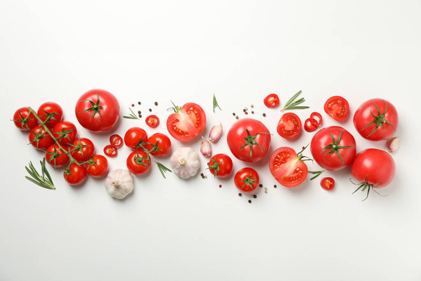 Composizione con pomodori e ingredienti su fondo bianco, vista dall'alto
 - Foto, immagini