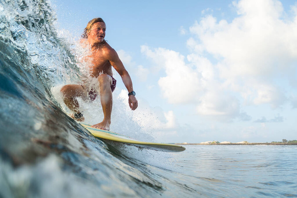 Young surfer rides ocean wave - 写真・画像