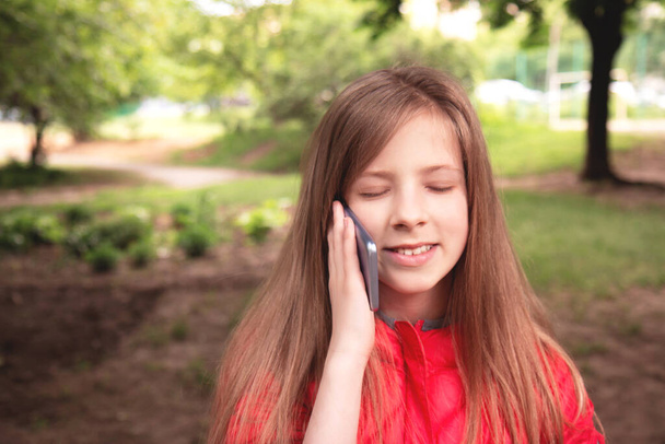 Молода красива дівчина з мобільним телефоном, на відкритому повітрі. Мобільна реклама
. - Фото, зображення