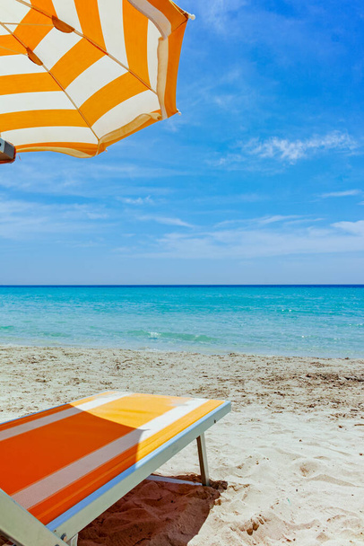 ビーチ設備、椅子、白い砂浜に太陽の傘ライトブルーの海の水、ビーチの休暇のコンセプト - 写真・画像