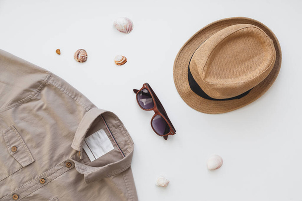 Модная концепция, мужская рубашка и солнечные очки изолированы на белом фоне. Плоская кладка, концепция летнего стиля - Фото, изображение