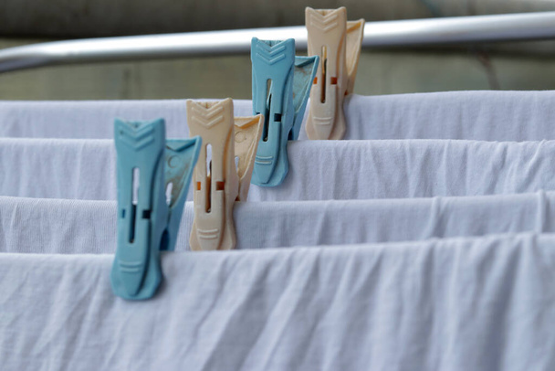Vêtements blancs séchant sur des cornes à linge debout avec des pinces à linge usure intérieure blanche sur sèche-linge Rack vêtements pliables cheval avec des vêtements pinces à linge en plastique
 - Photo, image