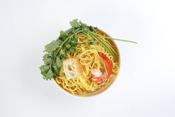 Φρέσκο κίτρινο αυγό noodle γαρίδα tofu φύλλα κόλιανδρου σε μπολ σε λευκό φόντο - Φωτογραφία, εικόνα