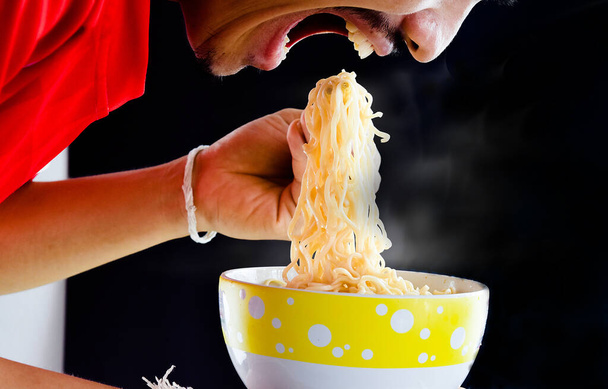 Un uomo che si diverte a mangiare spaghetti istantanei
 - Foto, immagini