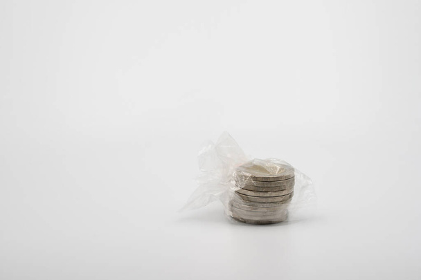 Paquete de plástico Thai Coin in Transparency en luz de estudio con fondo blanco. - Foto, imagen