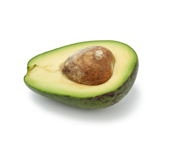 half an avocado green with brown seeds inside isolated on a white background, top view - Foto, immagini