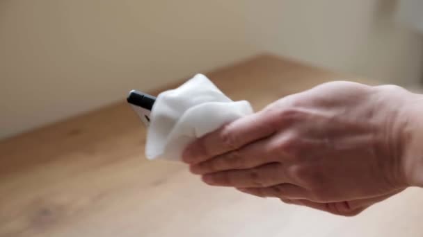Weibliche Hände reinigen Mobiltelefon mit antibakteriellen Feuchttüchern. Frau putzt und desinfiziert Handy zu Hause - Filmmaterial, Video