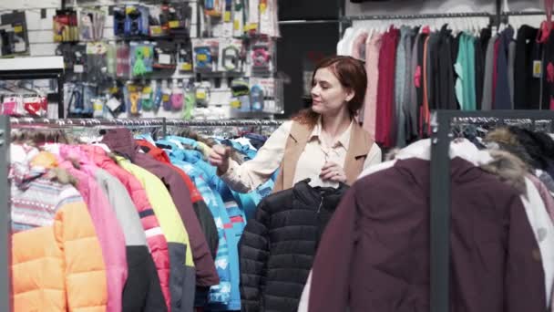 Shopaholic, schöne Shopperin, die Kleidung aus den Regalen pflückt - Filmmaterial, Video