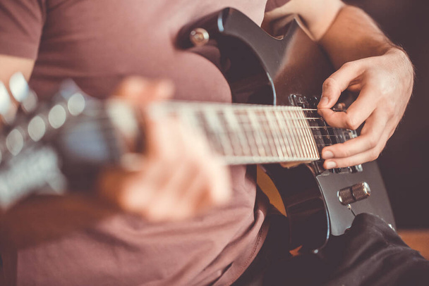 De cerca la mano de un joven tocando en una guitarra eléctrica profesional, negro, instrumento de música, entretenimiento, estilo de vida
 - Foto, Imagen