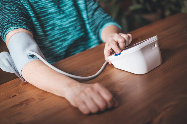 Žena zdravotní kontrola krevní tlak a srdeční frekvence doma s digitálním tlakem, zdraví a lékařské koncepce - Fotografie, Obrázek