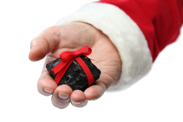 μια άνθρακα με κόκκινη κορδέλα στο χέρι του Αϊ-Βασίλη - Φωτογραφία, εικόνα