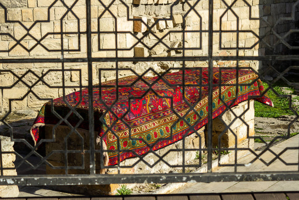 Alfombras nacionales con patrones caucásicos están a la venta en el casco antiguo en piedras viejas
 - Foto, Imagen