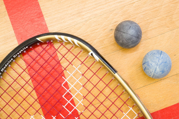 Nahaufnahme von Squash-Schläger und Ball auf dem hölzernen Hintergrund, Sportkonzept - Foto, Bild