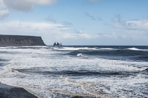 Avrupa, İzlanda 'nın güneyinde, kara kumsal Reynisfjara' da fırtınalı, kasvetli bir gün. Atlantik Okyanusunda büyük dalgalar var. - Fotoğraf, Görsel
