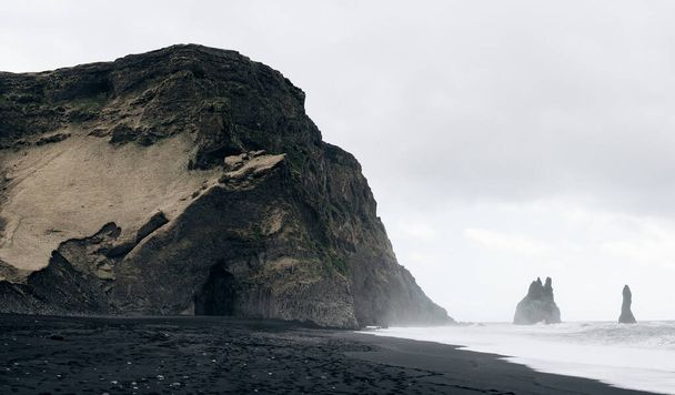 Black Beach Vik στην Ισλανδία. Κύματα του Ατλαντικού Ωκεανού. Πυλώνες βασάλτη στην ακτή. - Φωτογραφία, εικόνα